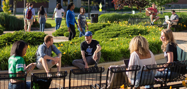 Students gather outside of the entrance to the Student Services Building on Grand Valley State University's Allendale Campus.